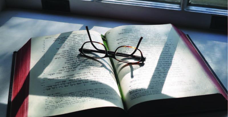 open book with a glasses over it