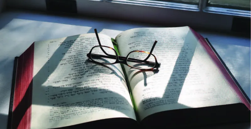 open book with a glasses over it