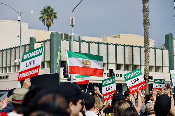 Photo of protesters holding Iranian flags